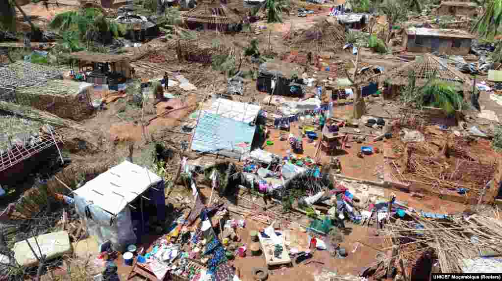 Pessoas no meio de edifícios destruídos, árvores desenraizadas e destroços após o ciclone Chido ter atingido Moçambique, no distrito de Mecufi, província de Cabo Delgado, Moçambique, a 16 de dezembro de 2024, nesta captura de ecrã retirada de um vídeo de um drone.