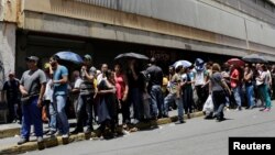 People queue to buy basic food items outside a supermarket in Caracas, Venezuela, April 28, 2016. President Nicolas Maduro ordered on May 1, 2016, a 30 percent increase in the country's minimum wage.