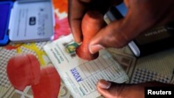 Un agent électoral appose le sceau sur le bulletin d’un électeur qui vient de voter lors des législatives à Abidjan, Côte d’Ivoire, 18 décembre 2016. REUTERS/Thierry Gouegnon