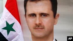 Drapeau syrien à côté d'une photo du président syrien Bachar el-Assad.