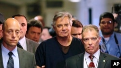 Paul Manafort (au milieu, en noir), ancien directeur de campagne du président américain Donald Trump, arrive au tribunal le 27 juin 2019 à New York. Il figure parmi les personnes qui bénéficie de la grâce du président.