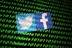 FILE - The Twitter and Facebook logos are seen with binary cyber codes in this illustration, Nov. 26, 2019.