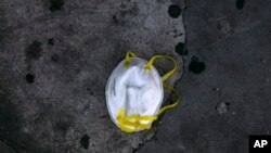 A face mask is discarded on a sidewalk during the coronavirus outbreak in Los Angeles, May 21, 2020.