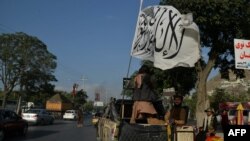 Taliban fighters travel on a vehicle mounted with the Taliban flag in the Karte Mamorin area of Kabul city, Kabul on Aug. 22, 2021. 