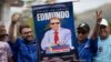 Dos militantes del partido opositor Un Nuevo Tiempo muestran un afiche con la imagen del candidato presidencial Edmundo González Urrutia durante una concentración con el postulado y la dirigente María Corina Machado en Aragua, el 18 de mayo de 2024.