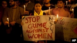 FILE - Indian youth hold candles during a protest against sexual violence in New Delhi, Feb. 9, 2015.