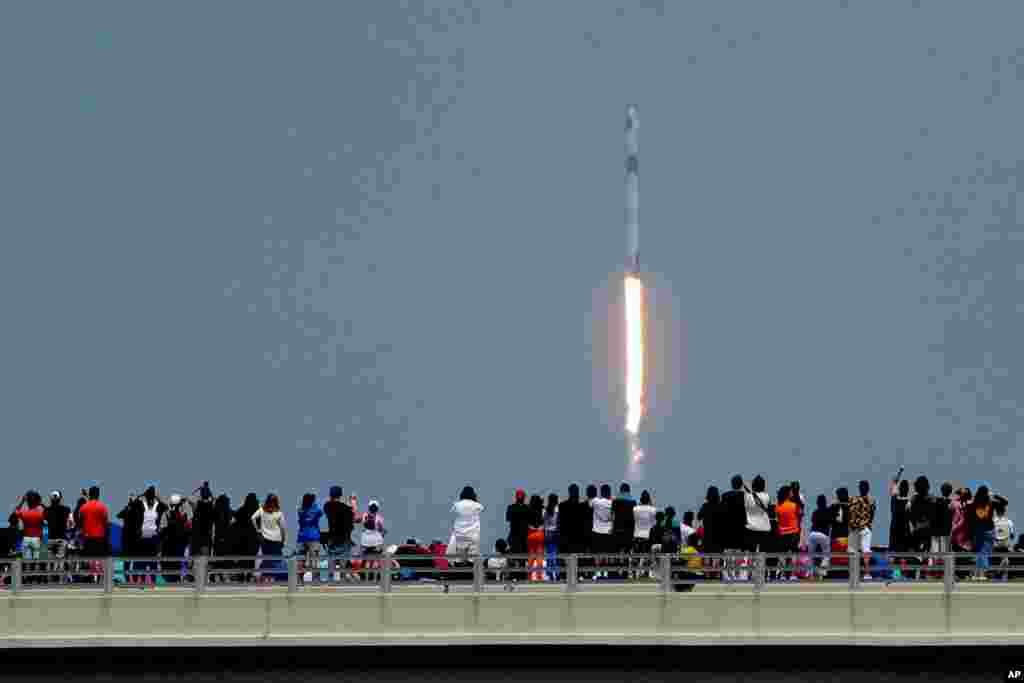 Los espectadores observan desde un puente en Titusville, Florida, mientras el SpaceX Falcon 9 despega
