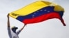 ARCHIVO - Un manifestante antigubernamental enmascarado ondea una bandera venezolana durante las protestas en Caracas, Venezuela, el 1 de mayo de 2019.