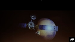 A rendering of the Schiaparelli Space Module and of the planet Mars is displayed on a movie screen, during an event on the occasion of the insertion of the Trace Gas Orbiter into orbit around Mars, and landing of the Schiaparelli module on the surface of the planet, in Rome, Oct. 19, 2016.