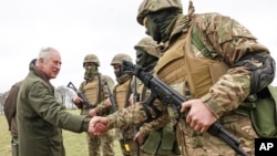 Через ризик бомбардувань тренувальних центрів Україна змушена відправляти військових на підготовку за кордон. На архівному фото король Великої Британії Чарльз III з українськими новобранцями, яких навчають у Вілтширі, Англія. 20 лютого 2023 р. (Фото AP)