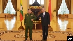 El jefe militar de Birmania, y ahora líder del país, el general Min Aung Hlaing, a la izquierda, y el ministro de Exteriores chino Wang Yi, posan para una foto durante su reunión el 12 de enero de 2021.