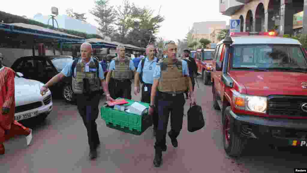 Des gendarmes français transportent du matériel médico-légal dans le hall de l'hôtel Radisson à Bamako, au Mali, 20 novembre 2015.