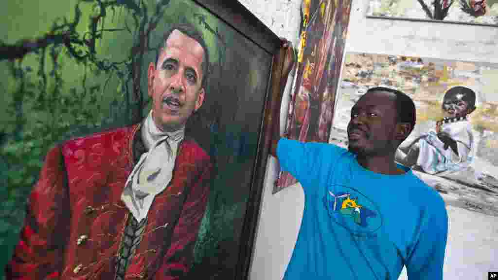 Le peintre kenyan Evans Yegon, connu sous le nom " Yegonizer ", pose à cots de deux tableaux du président americain, le 22 juillet 2015.