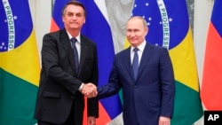 Президент Росії Володимир Путін і президент Бразилії Жаїр Болсонару потискають руки після переговорів у Кремлі 16 лютого 2022 р. (Mikhail Klimentyev, Sputnik, Kremlin Pool Photo via AP)