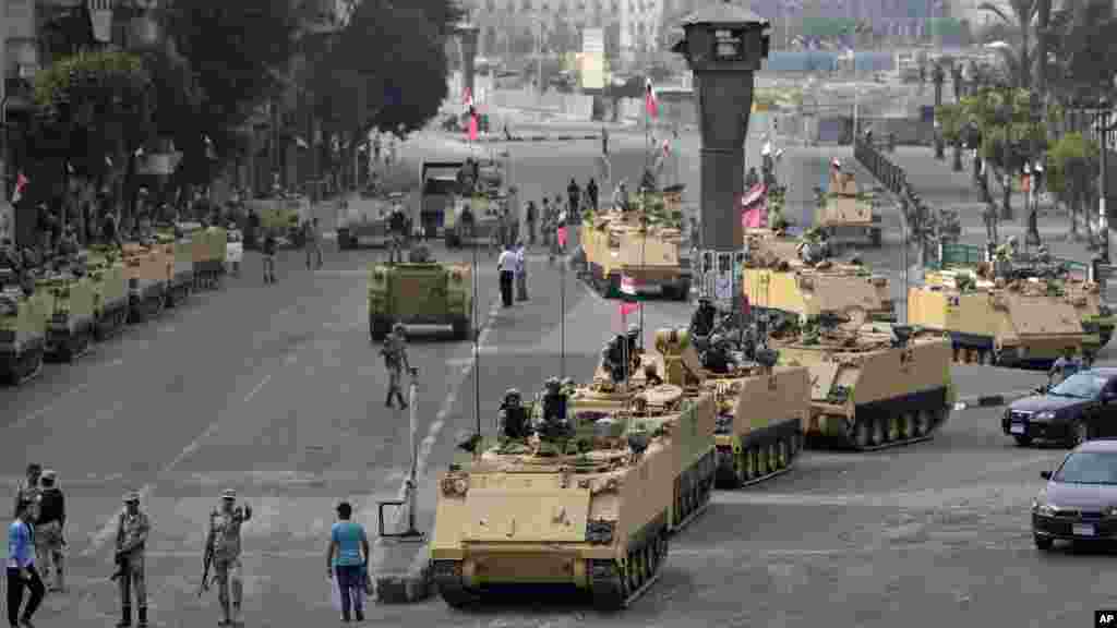 Egyptian army soldiers take their positions on top and next to their armored vehicles while guarding an entrance to Tahrir square, in Cairo, Egypt, Friday, Aug. 16, 2013.