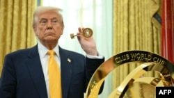 Дональд Трамп держит ключ, который открывает трофей чемпионата мира по футболу, 7 марта 2025