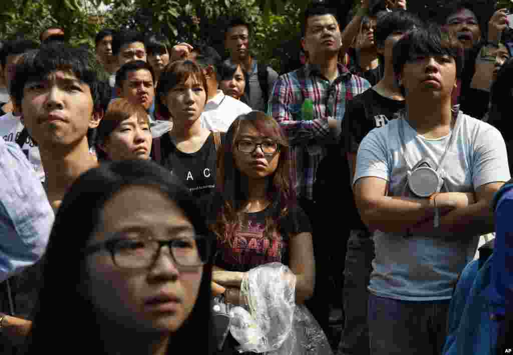 Pro-democracy protesters watch as police officers remove the barricades on the main roads of Central district in Hong Kong, Tuesday, Oct. 14, 2014.