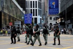 La policía antidisturbios levanta una bandera de advertencia mientras dispersan a los manifestantes antigubernamentales en el Distrito Central en Hong Kong.