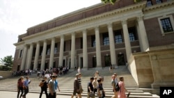 Orang-orang berjalan melewati pintu masuk Perpustakaan Widener di kampus Universitas Harvard, di Cambridge, Massachusetts, 16 Juli 2019. (Foto: AP)