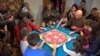 Children participate in the mandala dismantle ceremony that follows the completion of the art. (VOA/ J. Soh)