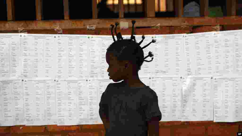 La silhouette d’une enfant devant la liste des électeurs à un bureau de vote à Bangui, en République centrafricaine, 14 février 2016.