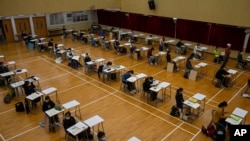 Students wearing masks to help stop the spread of the new coronavirus, sit for the Diploma of Secondary Education (DSE) exams at a school in Hong Kong, April 24, 2020.