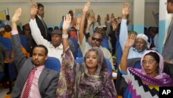 FILE - Somalia lawmakers raise their hands during a confidence vote on Prime Minister Abdiweli Sheikh Ahmed, at the Parliament Building in Mogadishu, Somalia.