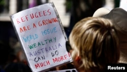 Demonstran membawa poster bertuliskan pesan pembelaan terhadap pengungsi di pusat kota Sydney, Oktober 2014. (Reuters/David Gray)