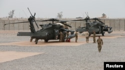 Beberapa tentara AS berdiri di dekat dua helikopter Amerika di pangkalan udara Qayyarah, Irak (foto: dok). 