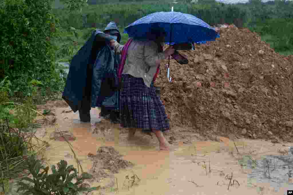 La gente camina alrededor de una carretera bloqueada por un deslizamiento de tierra en Purulha, en el norte de Guatemala, el viernes 6 de noviembre de 2020.