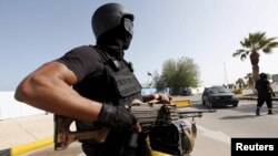 Seorang anggota pasukan keamanan untuk Libya berjaga di pintu depan sebuah kantor pemerintah di Tripoli, Libya (14/4). 