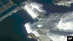 In this image taken from NASA video, NASA astronauts Kate Rubins, top, and Victor Glover work outside the International Space Station, Feb. 28, 2021.