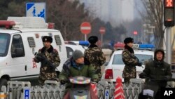 Armed Chinese paramilitary policemen stand guard in the capital city's popular shopping and tourist area of Wangfujing in Beijing, Dec. 27, 2015. China’s rubber-stamp national legislature approved the country’s first anti-terrorism law, amid concerns that its requirements that tech companies share information with the government could hurt business interests and further infringe upon human rights.