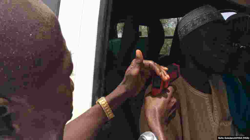 Mr. Jibrin Zakari jami'in kiwon lafiya daga Najeriya na auna zafin jikin fasenjoji dake shiga Najeriya, domin tantance ko suna dauke da cutar Ebola.