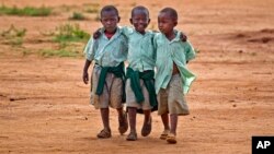 FILE - Young schoolboys walk home in the village of Nyumbani, Kenya, which caters to children who lost their parents to HIV, and grandparents who lost their children to HIV.
