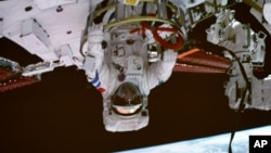 In this photo released by Xinhua News Agency, screen image captured at the Beijing Aerospace Control Center on Sept. 1, 2022 shows Shenzhou-14 astronaut Chen Dong exiting the space station lab module Wentian orbiting earth.