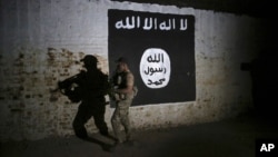 Un soldat irakien inspecte un tunnel orné d'un drapeau du groupe État islamique le 1er mars 2017.