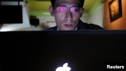 Vietnamese Internet activist Nguyen Lan Thang chats on Facebook at a cafe in Hanoi November 27, 2013. Vietnam will hand out fines of 100 million dong ($4,740) to anyone criticising the government on social media, under a new law announced this week, the latest measure in a widening crackdown on dissent by the country's communist rulers.