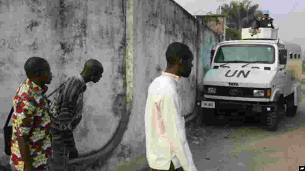 Des manifestants se cachent à l'arrière d'in véhicule de l'ONU alors que la police tire et lance des gaz lacrymogènes lors d'une manifestation, lundi 10 Janvier, 2005. . (AP Photo / John Bompengo)