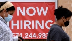 Arhiva - Women walk past by a 'Now Hiring' sign outside a store in Arlington, Virginia, Aug. 16, 2021.. 