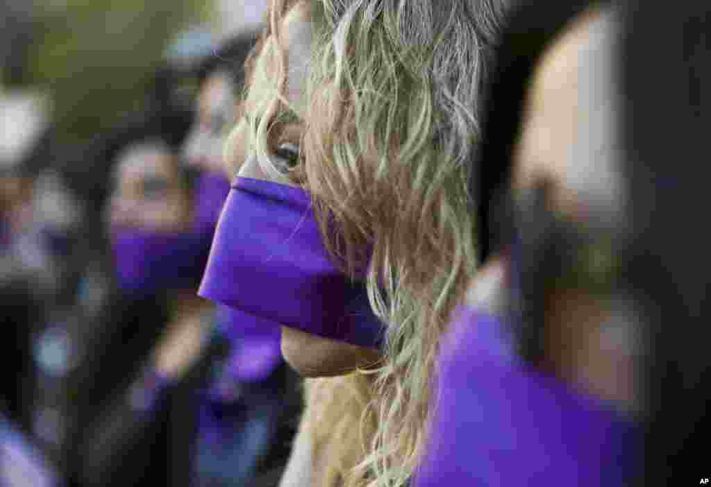 Women wear purple ribbons on their faces during the "Todas en Silencio" demonstration to mark the U.N.-designated International Women's Day, in front of La Moneda presidential palace in Santiago, Chile, March 8, 2017.