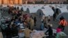 Para penyintas gempa yang kehilangan rumah, berbaris untuk menerima makanan di kamp darurat, di kota Iskenderun, Turki selatan, Selasa, 14 Februari 2023. (AP/Hussein Malla)