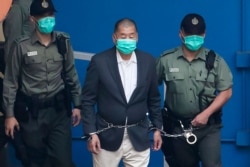 資料照：香港壹傳媒集團創辦人黎智英在港警看押下走向法庭。 （2020年12月12日）