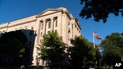 ARCHIVO - En esta fotografía del 8 de octubre de 2020, una bandera estadounidense ondea frente al edificio del Departamento de Justicia en Washington. 