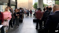 FILE - Immigrants awaiting deportation hearings line up outside the building that houses the immigration courts in Los Angeles, June 19, 2018. (AP Photo/Amy Taxin, File)