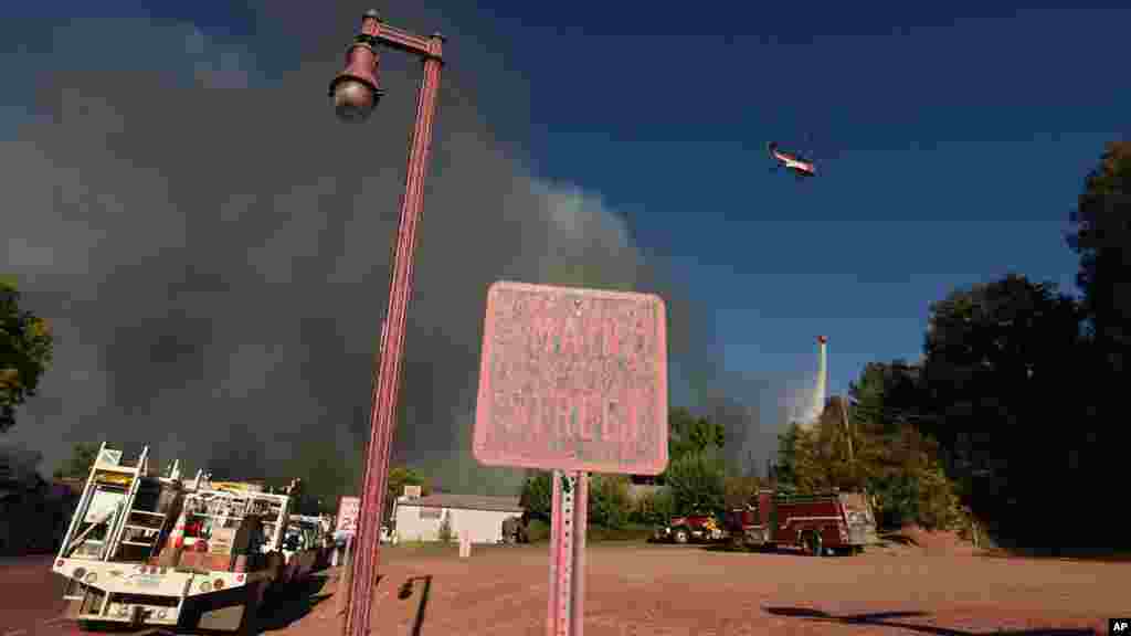 Un hélicoptère bombardier d'eau répand un produit ignifugé sur la région en proie aux incendies, le 14 août 2016.