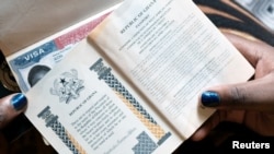 Une Ghanéenne montre les passeports de sa famille et un visa américain à Accra, au Ghana, le 1er février 2019. (Photo: Reuters/Francis Kokoroko/archives)