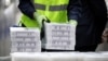 Pfizer employees handle containers of vaccine as U.S. President Joe Biden tours a Pfizer manufacturing plant producing the coronavirus vaccine in Kalamazoo, Michigan, Feb. 19, 2021. 