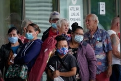 FILE - People line up outside a Kentucky Career Center hoping to find assistance with their unemployment claim in Frankfort, Kentucky, June 18, 2020.