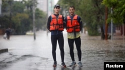 Los remeros preolímpicos brasileños Evaldo Mathias Becker y Piedro Tuchtenhagen posan para una fotografía mientras ayudan a rescatar a las víctimas de las inundaciones en Porto Alegre, estado de Rio Grande do Sul, Brasil, 10 de mayo de 2024.